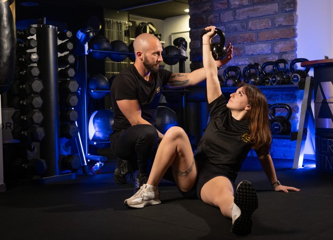 Coaching musculation à Bastia : un coach d’Alter Ego Fitness encadre une séance personnalisée avec haltère kettlebell, dans une salle moderne en Corse.
